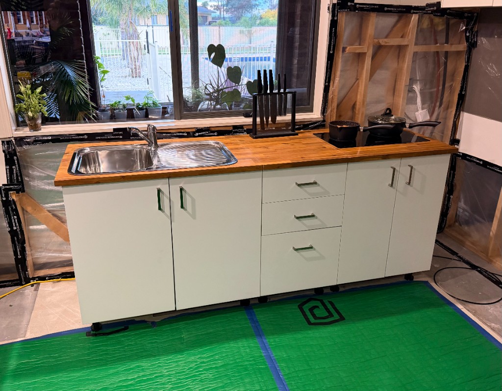 Installed temporary kitchen with sink, bench space, and cooking area